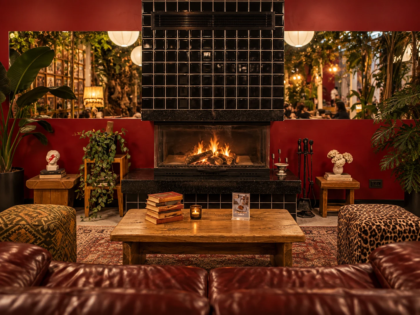 Warm fireplace surrounded by burgundy walls, books and vintage furniture